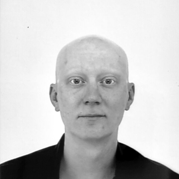 Portrait von Jan Borreck in schwarz-weiß. Er schaut gerade in die Kamera, trägt eine Glatze und ein schwarzes Hemd.  © Jan Borreck