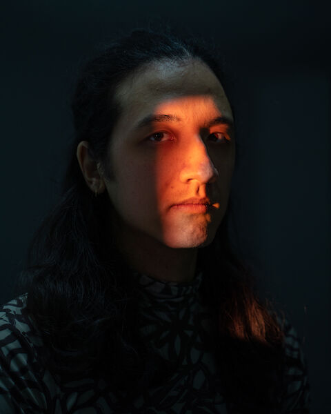 Portrait of Nathan Ishar illuminated by the light of the slide projector