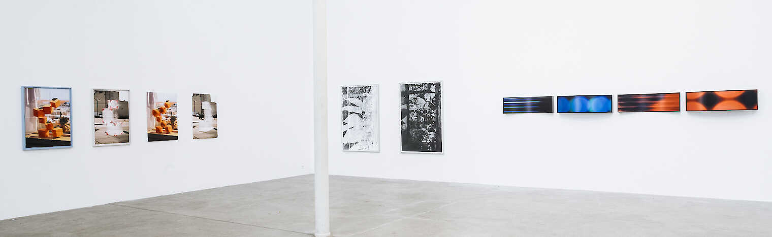 Das Bild zeigt ein weitläufiges Museum oder eine Galerie mit hohen, weißen Wänden und moderner Architektur. Kunstwerke hängen an den Wänden, und durch große Fenster fällt helles, diffuses Tageslicht ein.